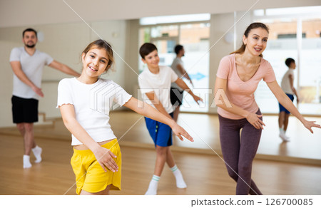 Girl exercising during family dance class 126700085