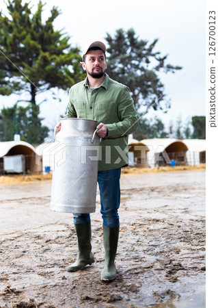 Man farmer standing with big milk can 126700123