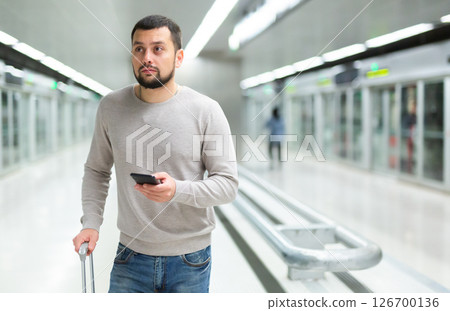 Portrait of confident man traveling on subway and using smartphone Portrait of confident man traveling on subway and using smartphone 126700136
