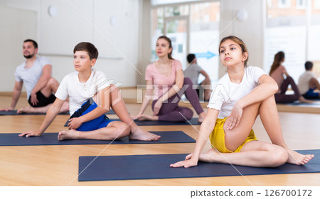 Family of four practicing yoga at gym 126700172