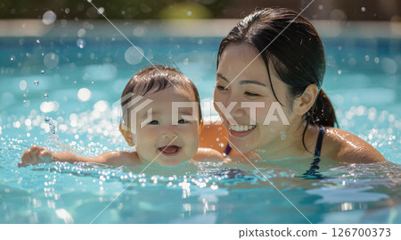 微笑的父母和孩子在游泳池裡玩耍 微笑的父母和孩子在游泳池裡玩耍 126700373