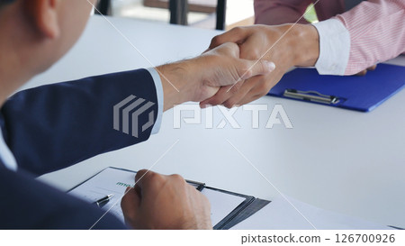Team Business Partners shaking hands together to Greeting Start up new project. Shakehand Teamwork Partnership at office desk. Businessman partners handshake together. Business concept 126700926