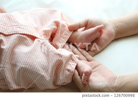 Baby's tiny feet and mom's hands Baby's tiny feet and mom's hands 126700998