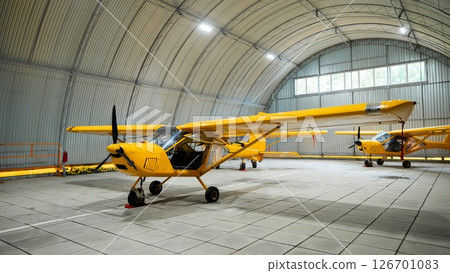 Yellow airplane glider in the hangar.  126701083