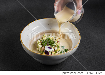 Cold summer soup okroshka. Light soup in a white bowl.  126701124