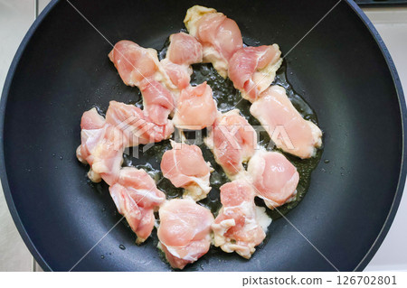 Cooking chicken in a frying pan Cooking chicken in a frying pan 126702801