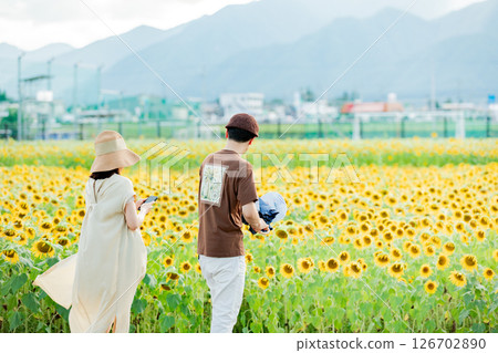 <安曇野> 一對情侶在新村的向日葵田裡玩耍 126702890
