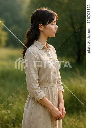 站在安靜草地上的女人的側面像 站在安靜草地上的女人的側面像 126703111