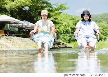 Camping: Woman dipping her feet in the river 126703545