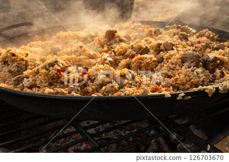 Rustic rice dish cooking on open fire 126703670