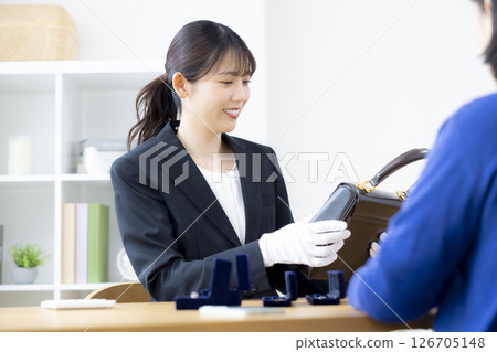 現場購買：一位女士正在評估一件商品 126705148