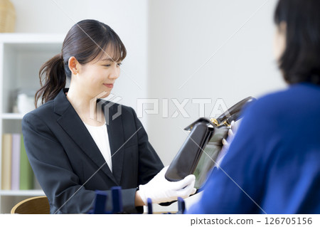 On-site purchase: A woman assessing an item 126705156