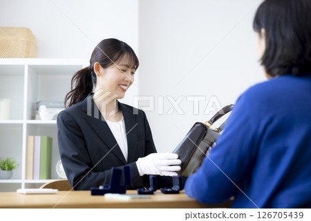 現場購買:一位女士正在評估一件商品 現場購買:一位女士正在評估一件商品 126705439