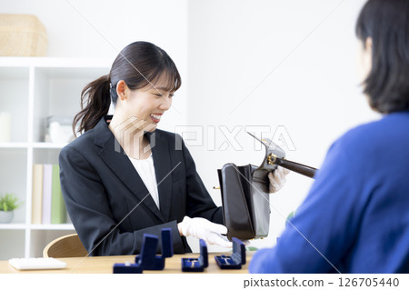 現場購買：一位女士正在評估一件商品 126705440