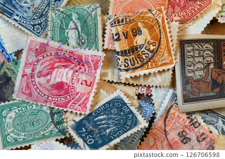 Closeup on a scattered collection of a variety of international used Vintage Postage Stamps 126706598