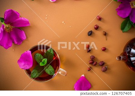 Top view of brewed rosehip tea with mint in glassware on brown background 126707405