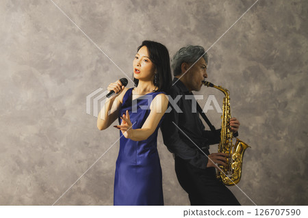 一名男子吹奏薩克斯,一名女子唱歌 一名男子吹奏薩克斯,一名女子唱歌 126707590