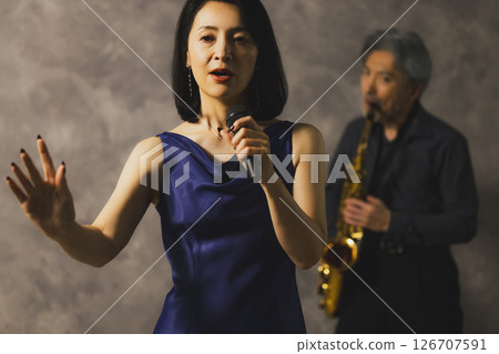 A man playing saxophone and a woman singing 126707591