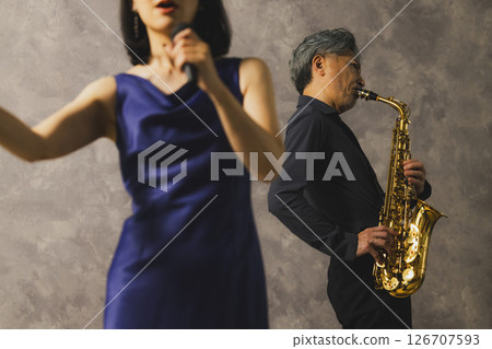 一名男子吹奏薩克斯,一名女子唱歌 一名男子吹奏薩克斯,一名女子唱歌 126707593