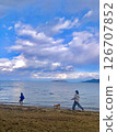 孩子們在藍天下寧靜的湖泊沙灘上遛狗 126707852