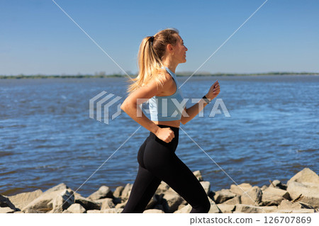 Sport woman morning running jogging on city river embankment side view Sport woman morning running jogging on city river embankment side view 126707869