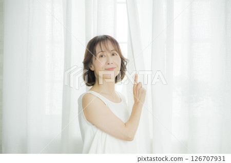 開窗簾的中年女人 126707931