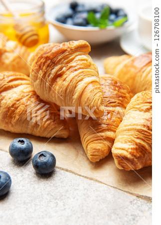 Freshly baked croissants with honey, blueberries, and milk for breakfast 126708100