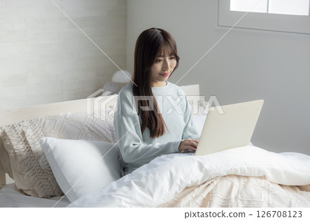 A woman who takes a computer at bed 126708123