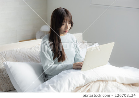A woman who takes a computer at bed 126708124