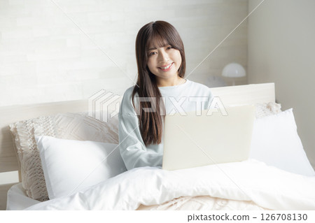 A woman who takes a computer at bed A woman who takes a computer at bed 126708130