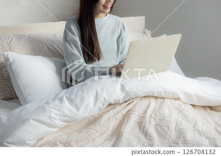 A woman who takes a computer at bed A woman who takes a computer at bed 126708132