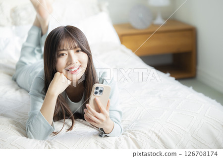 A woman watching a smartphone in bed 126708174