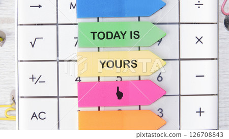 Motivational words TODAY IS YOURS motivating messages are placed on the calculator on bright stickers 126708843