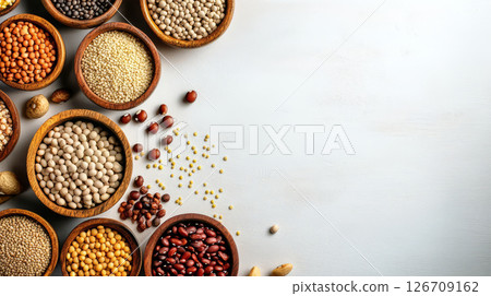 Wooden bowls filled with various grains and legumes arranged on table 126709162