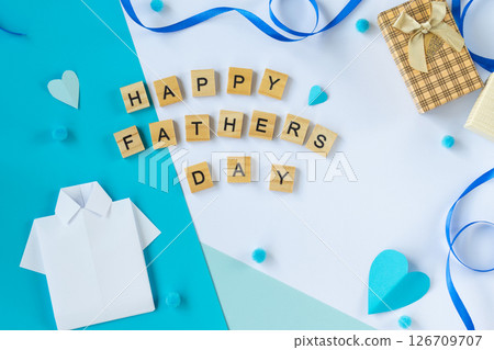 Greeting composition with Fathers Day wooden letters paper shirt tie hearts gift box blue background top view flat lay layout handmade dad celebration concept social content Greeting composition with Fathers Day wooden letters paper shirt tie hearts gift box blue background top view flat lay layout handmade dad celebration concept social content 126709707