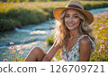 A young woman in a sunlit meadow near the river 126709721