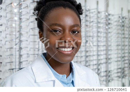 Female african american optician in a lab coat looking contented and positive 126710041
