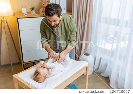 Young caucasian man changing diaper to his little baby boy 126710067
