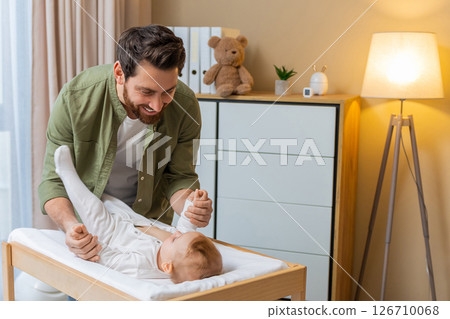Young caucasian man changing diaper to his little baby boy 126710068