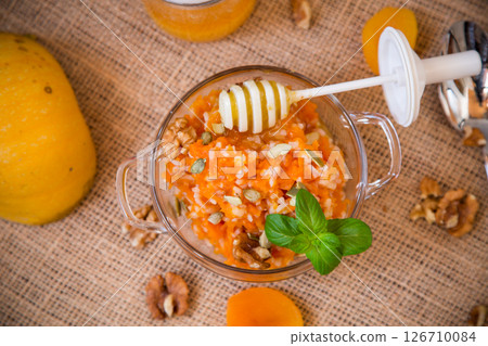 Cooked pumpkin porridge with rice, nuts and honey 126710084