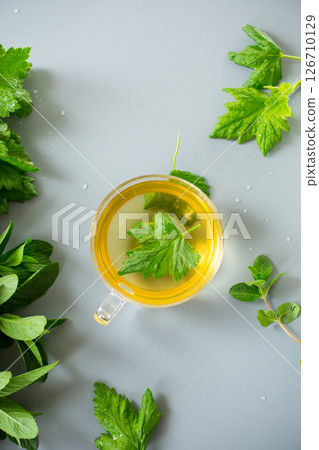 Green tea from currant leaves and mint in a glass container 126710129