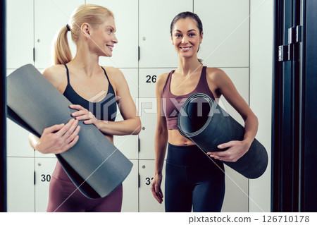 Two young women in sportswear in the gym looking excited 126710178