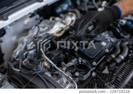 Mechanic checking engine oil in workshop 126710226