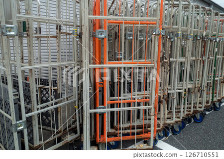 Many stacked basket trolleys in a retail store 126710551