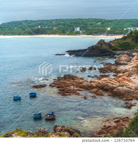 Landscape with Vietnamese round basket boats floating in sea next to the rocks. Da Da reef or Ganh Da Dia in Phu Yen province in Vietnam. Aerial top view from drone Landscape with Vietnamese round basket boats floating in sea next to the rocks. Da Da reef or Ganh Da Dia in Phu Yen province in Vietnam. Aerial top view from drone 126710764
