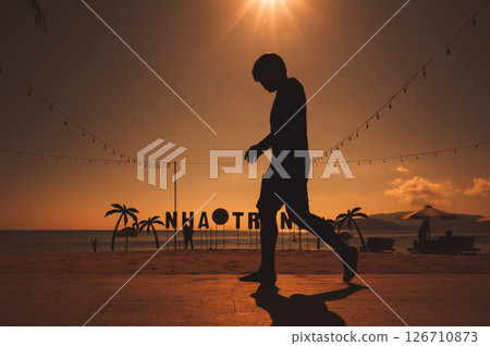 Silhouette of a Vietnamese man on the embankment by the beach with the sea in morning at sunrise in summer in Nha Trang, Vietnam Silhouette of a Vietnamese man on the embankment by the beach with the sea in morning at sunrise in summer in Nha Trang, Vietnam 126710873