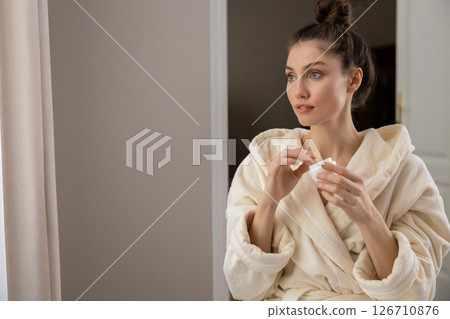 Cute woman with applies rejuvenating cream to her glowing face enjoying wellness Cute woman with applies rejuvenating cream to her glowing face enjoying wellness 126710876