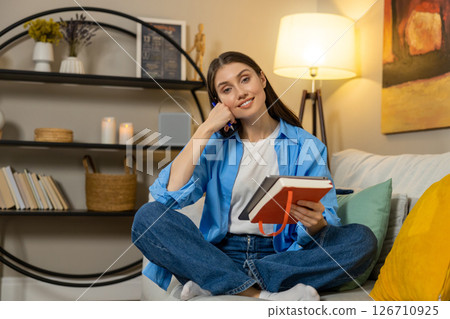 Smiling relaxed woman holding tab relaxing on sofa at home using digital tablet sitting on couch 126710925