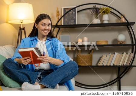 Woman working on digital tablet in apartment browsing internet indoors 126710926