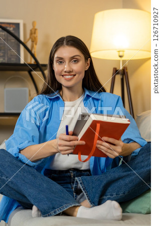 Woman reading e-book on e-reader in room chilling indoors enjoying browsing media 126710927